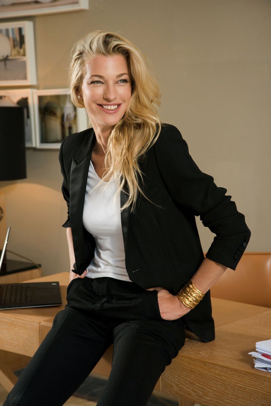 Nicole Junkermann in a black blazer and white top, smiling warmly in a bright room